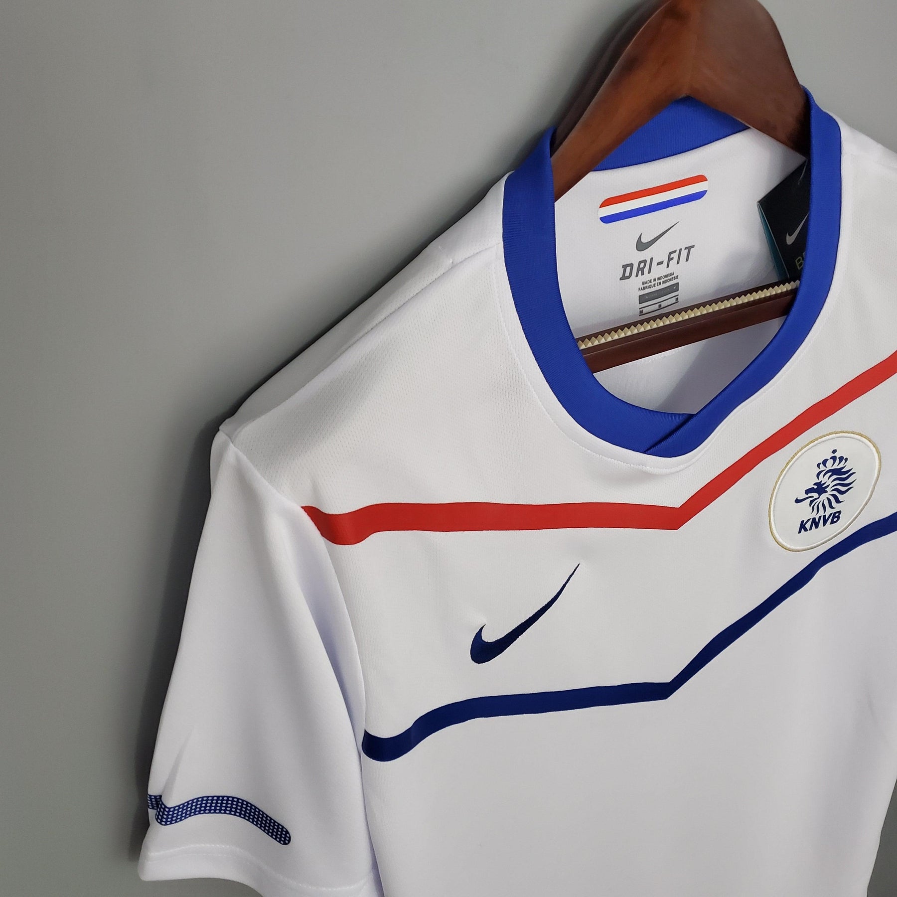 Camisola Holanda Away 12/13 Retro com detalhes em azul e vermelho, modelo DRI-FIT da Nike, disponível na OLYMPIC STORE.