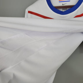 Camisola Holanda Away 12/13 Retro em detalhe, tecido branco com listras vermelhas e azul, disponível na OLYMPIC STORE.