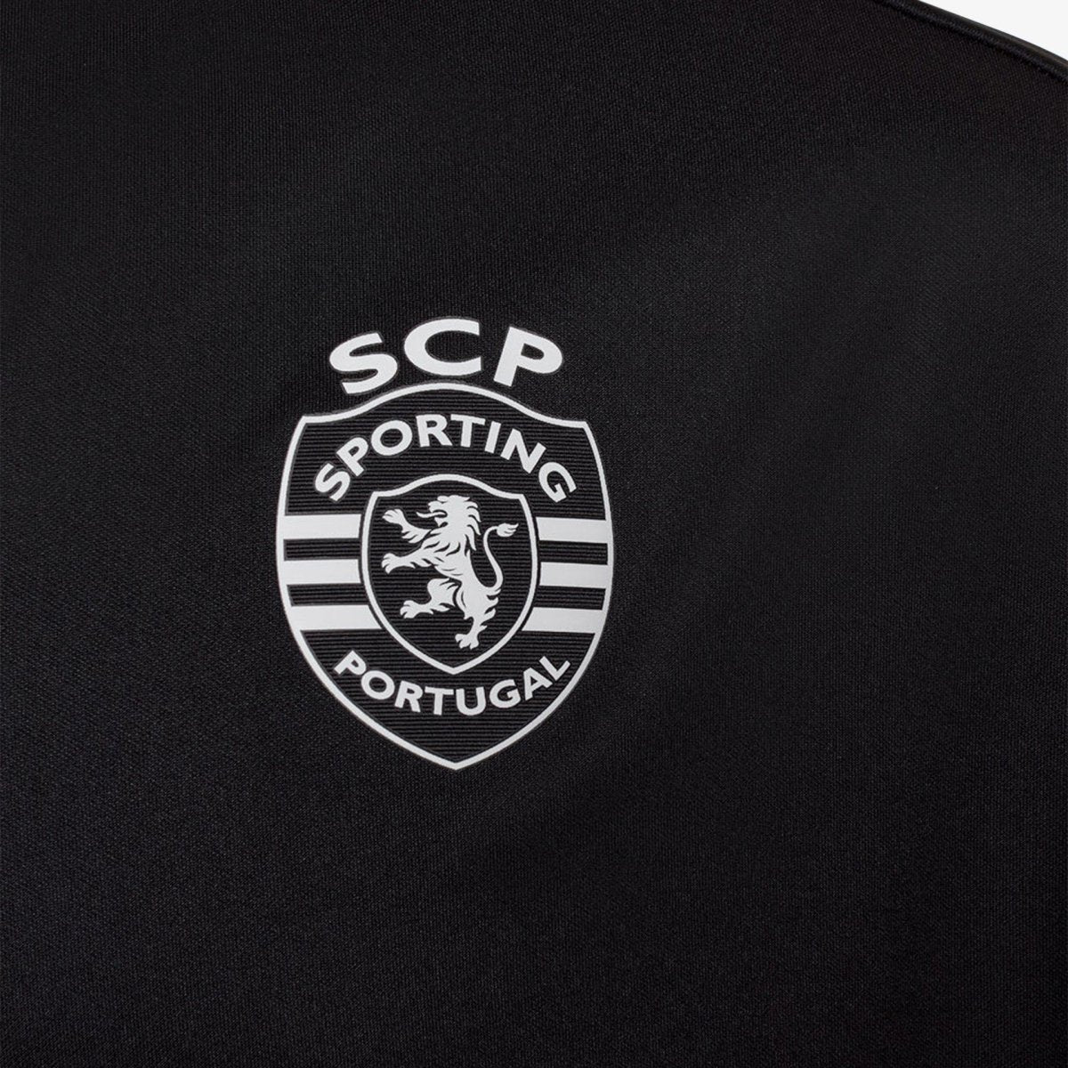 Logo do Sporting Portugal em um casaco de treino na cor preta, representando a marca SCP.