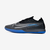 Chuteira Futsal Nike Gripknit Phantom GX Elite IC em fundo cinza, com detalhes em azul e preto.
