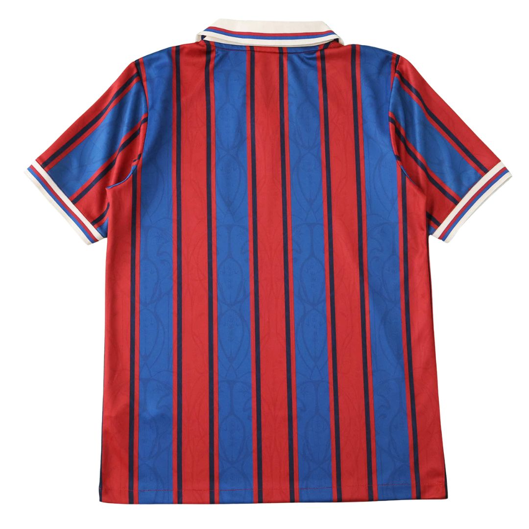 Camisola de futebol Barcelona, com listras verticais vermelhas e azuis, disponível na OLYMPIC STORE.