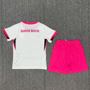 Conjunto infantil Sporting Outubro Rosa 2025/26 com camisola branca e calção pink, lançamento da OLYMPIC STORE.
