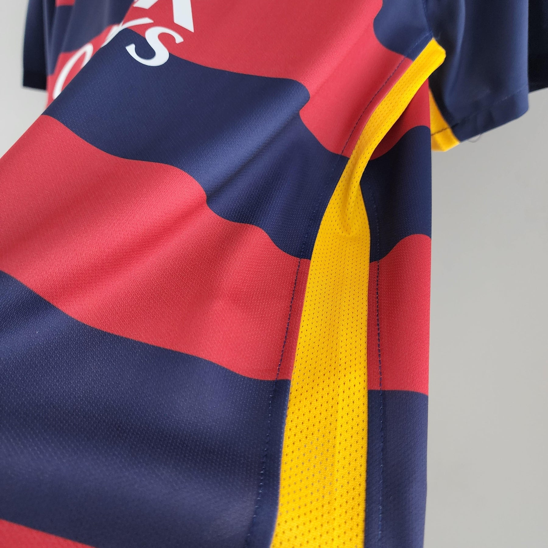 Camisa de futebol Barcelona 15/16 com detalhes em vermelho, azul e amarelo, disponível na OLYMPIC STORE.