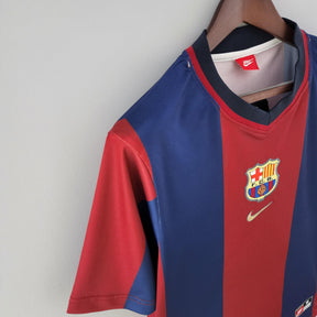 Camisa de futebol Barcelona Home 98/99 disponível na Olympic Store, em cores vermelha e azul, com escudo e logo Nike.