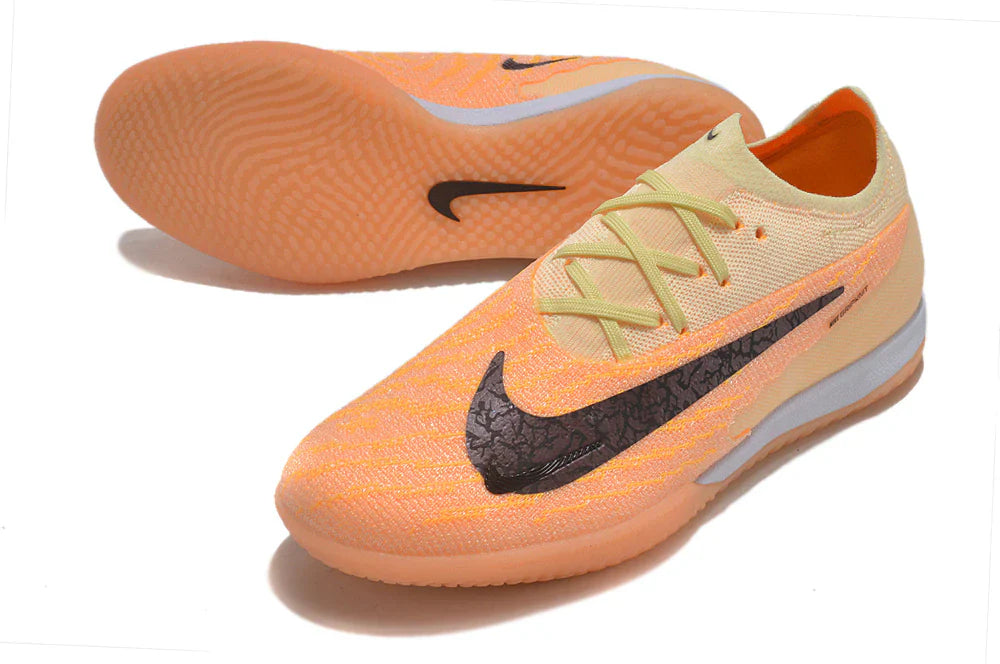 Chuteira Futsal Nike Gripknit Phantom GX Elite IC em tom laranja e preto com solado liso.
