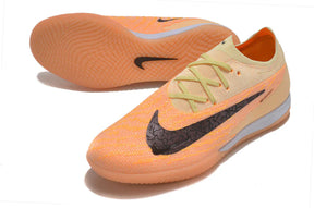 Chuteira Futsal Nike Gripknit Phantom GX Elite IC em tom laranja e preto com solado liso.