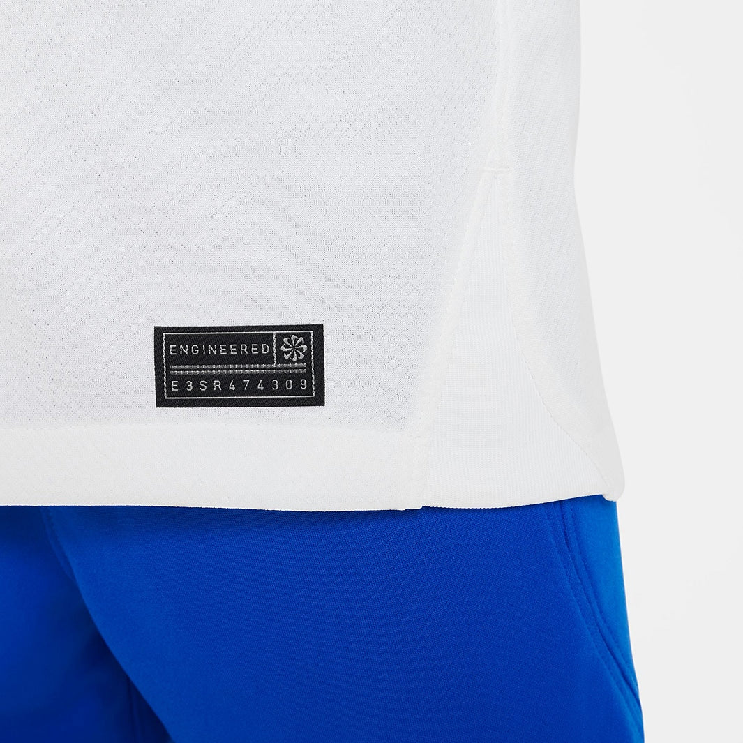 Conjunto Infantil Nike FC Barcelona 2023/24 II, detalhe da etiqueta de engenharia de camiseta e calça azul.