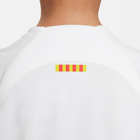 Conjunto Infantil Nike FC Barcelona 2023/24 II, detalhe das listras coloridas na parte de trás da camisa infantil.