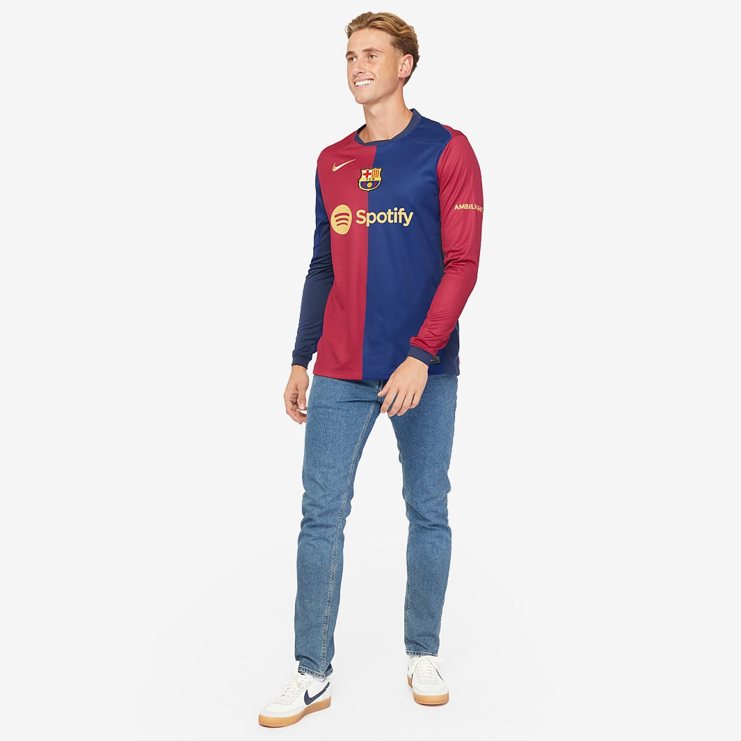 Modelo usando a camisola manga longa Nike FC Barcelona 2024/25 torcedor, em pé e sorrindo.