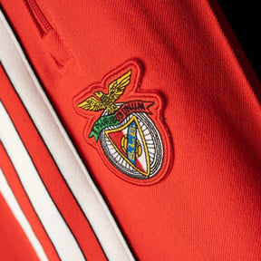Emblema do time Benfica em um fato de treino vermelho com detalhes em branco.