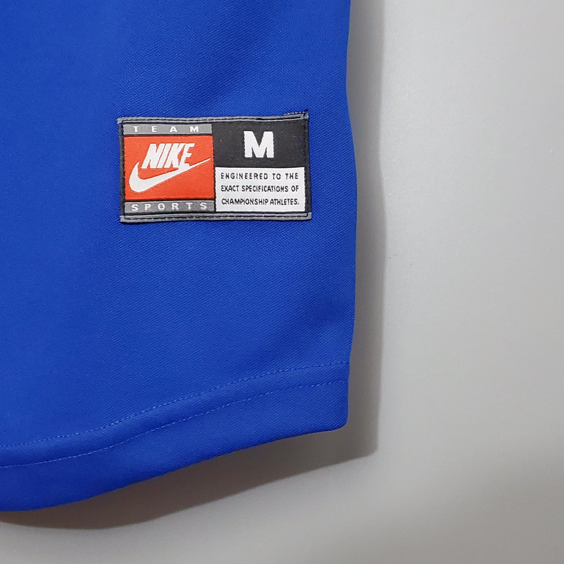 Etiqueta do produto Barcelona Home Edição Especial 100° Retro, destaque da Nike, tamanho M em tecido azul.