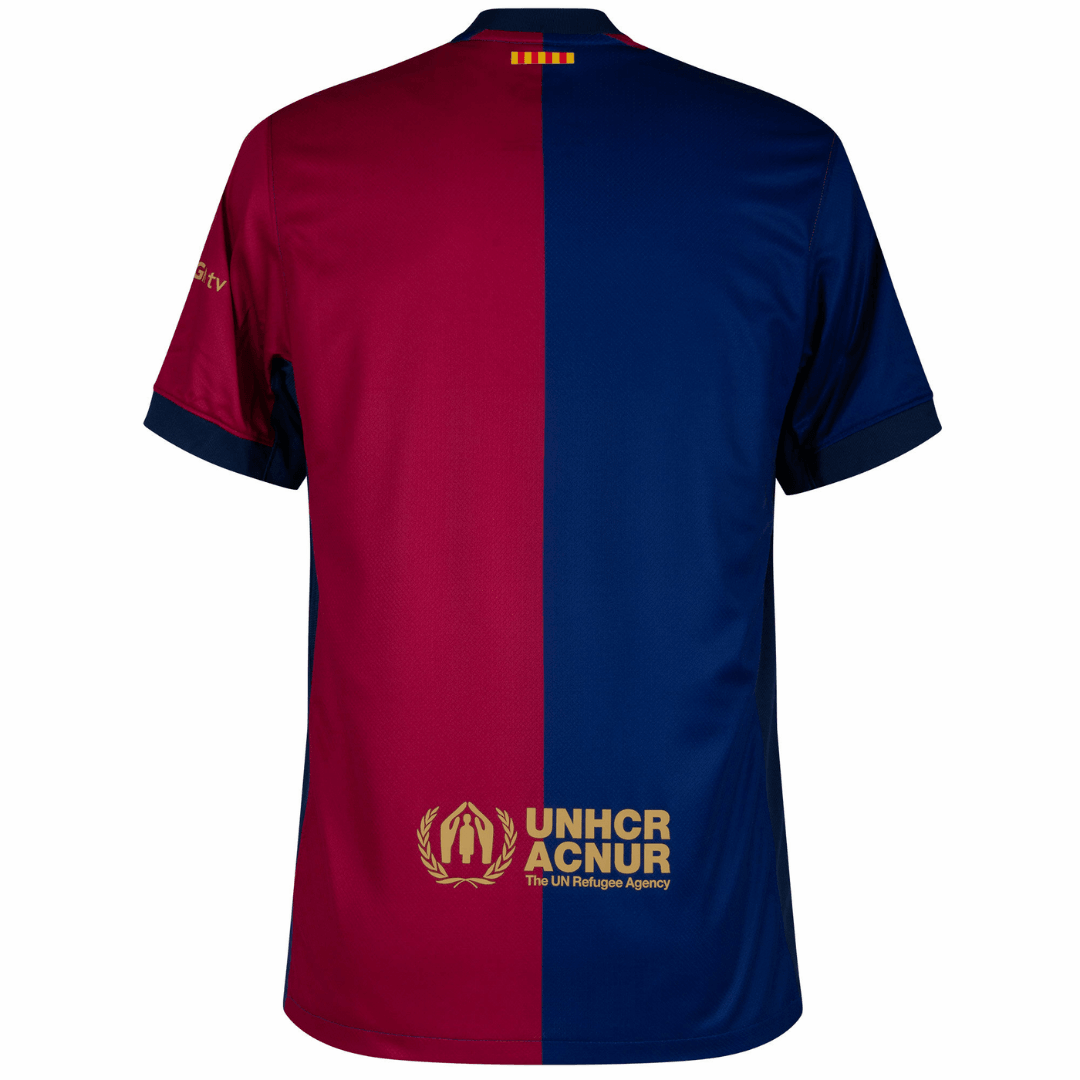 Camisa Barcelona home 24/25 com design em cores vermelho e azul, detalhes da marca e logo da UNHCR.