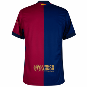 Camisa Barcelona home 24/25 com design em cores vermelho e azul, detalhes da marca e logo da UNHCR.