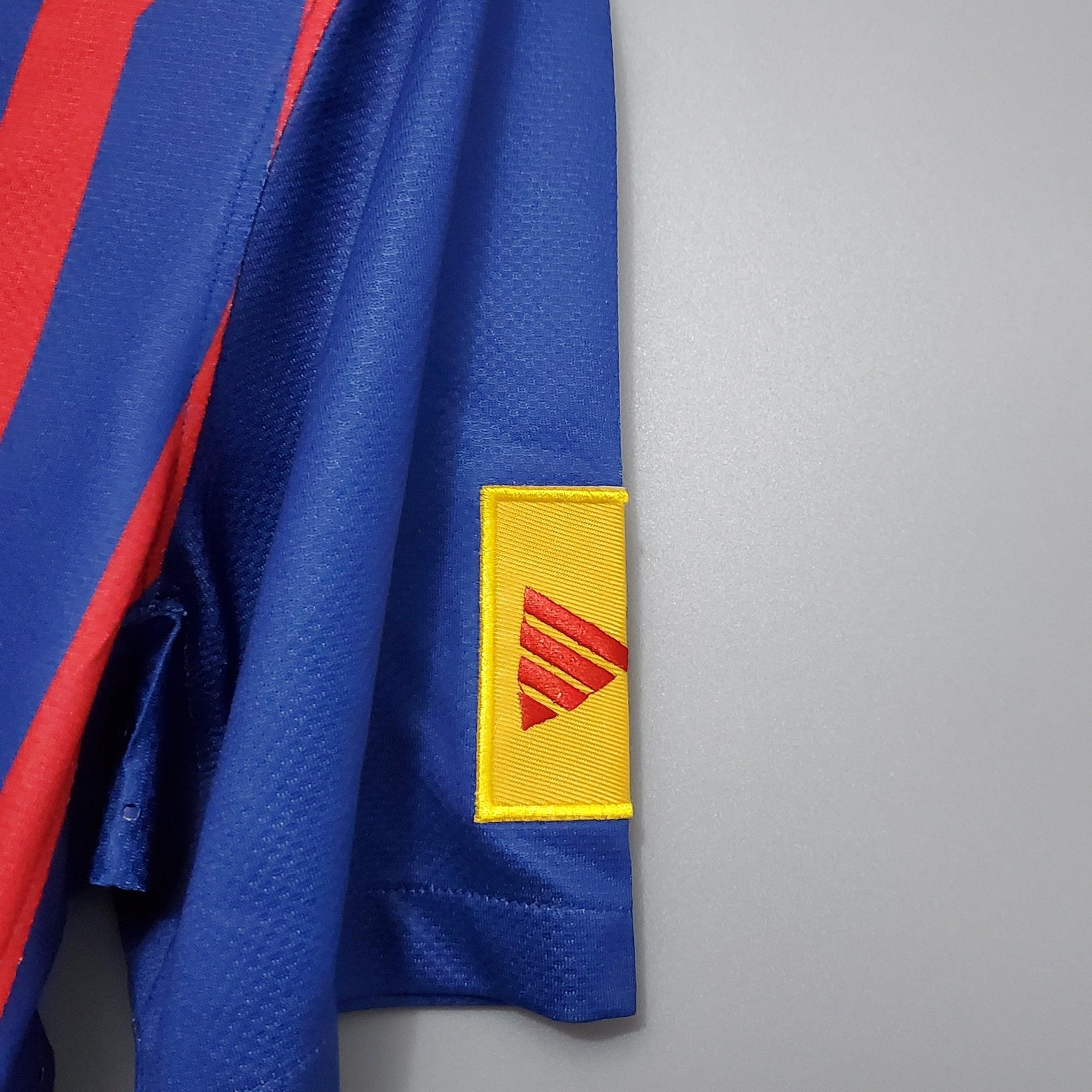 Camisa Barcelona Home 11/12 Retro com detalhe do logo da Adidas no braço.