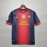 Camiseta Barcelona Home 12/13 Retro com detalhes em vermelho e azul, logotipo da Qatar Foundation.