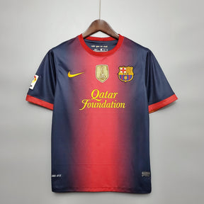 Camiseta Barcelona Home 12/13 Retro com detalhes em vermelho e azul, logotipo da Qatar Foundation.