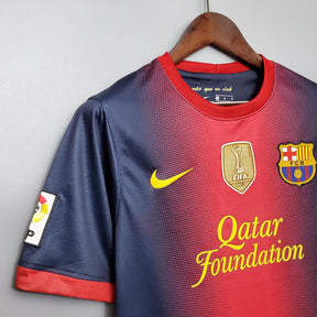 Camisa Barcelona Home 12/13 retro com detalhes em vermelho e azul, logotipo da Nike e Qatar Foundation.