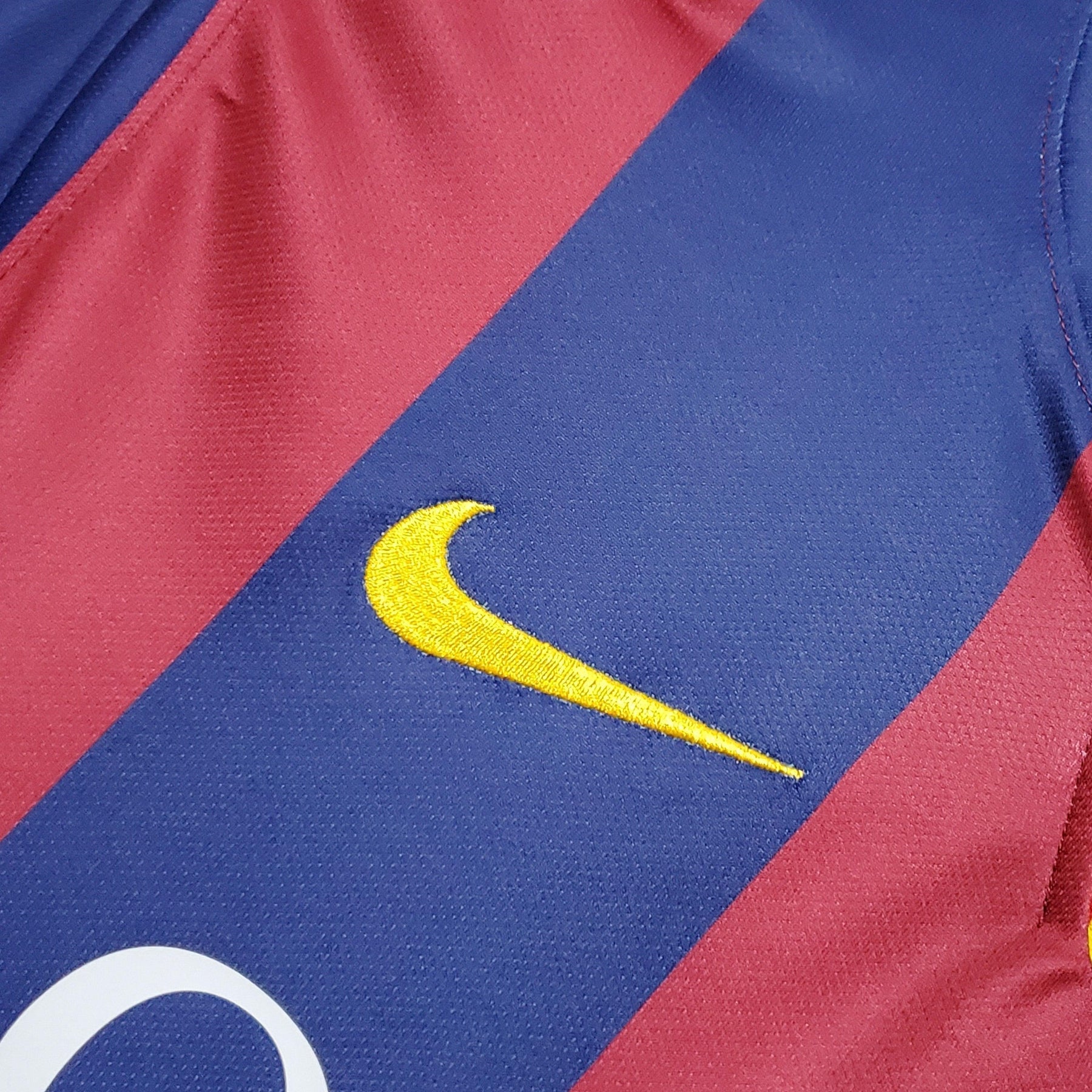 Detalhe do uniforme Barcelona Home 14/15 com logo Nike, disponível na loja retro olímpica.