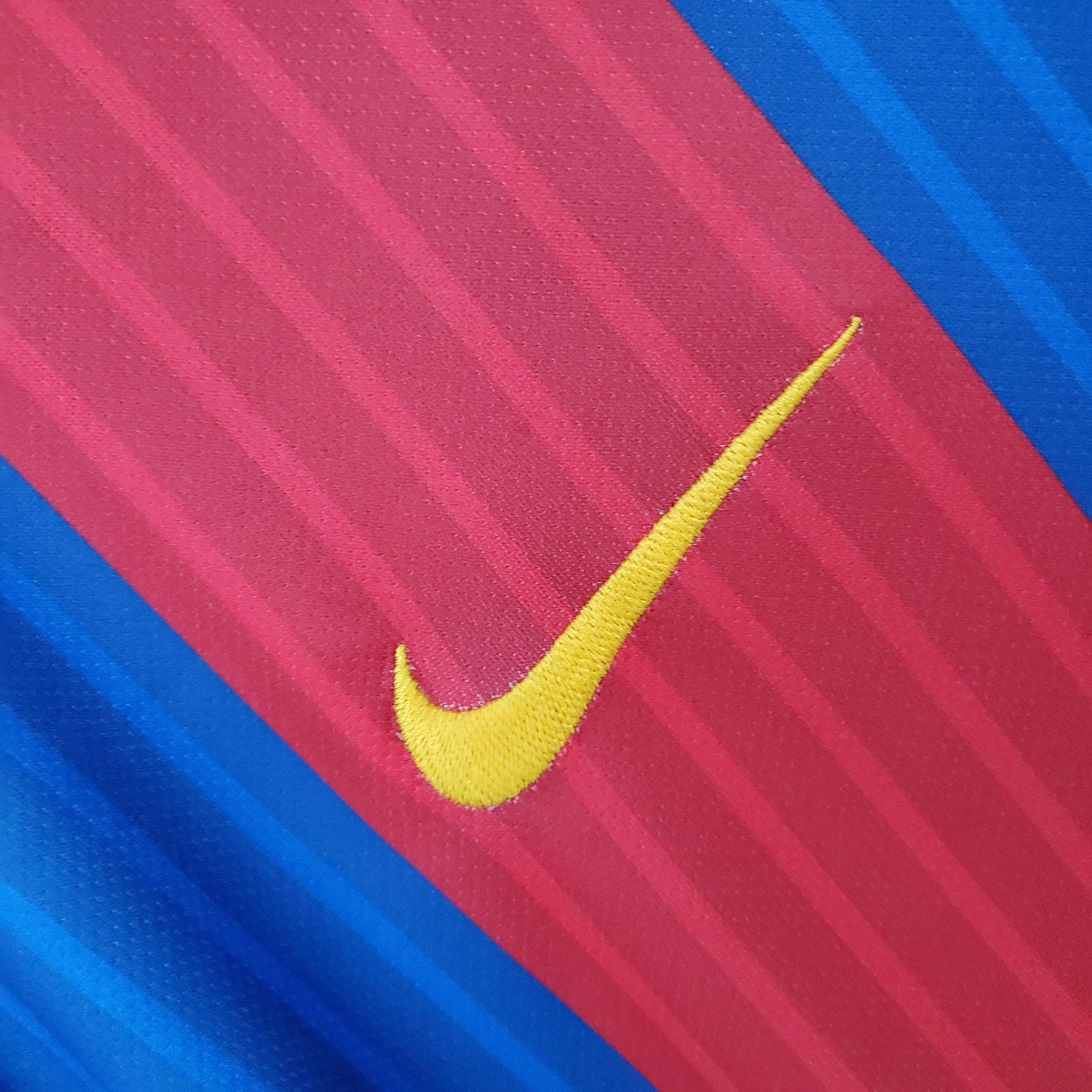 Detalhe do logotipo Nike na camisa Barcelona Home 16/17 Retro, destacando as cores vibrantes do time.