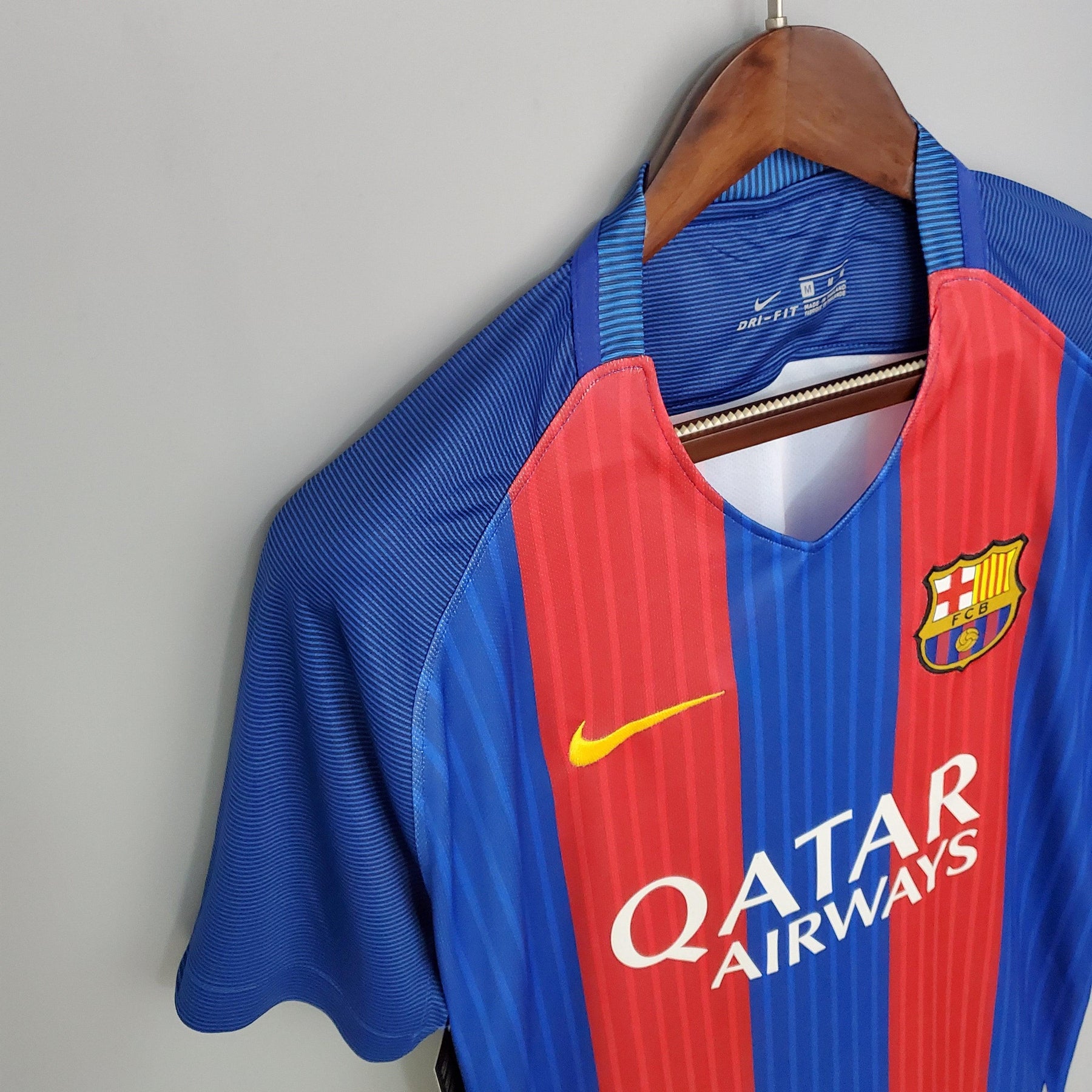 Camisa do Barcelona Home 16/17 disponível na Olympic Store, com logo da Nike e patrocínio da Qatar Airways.
