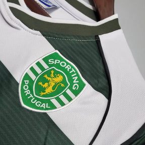 Camisola de futebol Sporting Lisboa com escudo em verde e branco, perfeita para os fãs do clube.