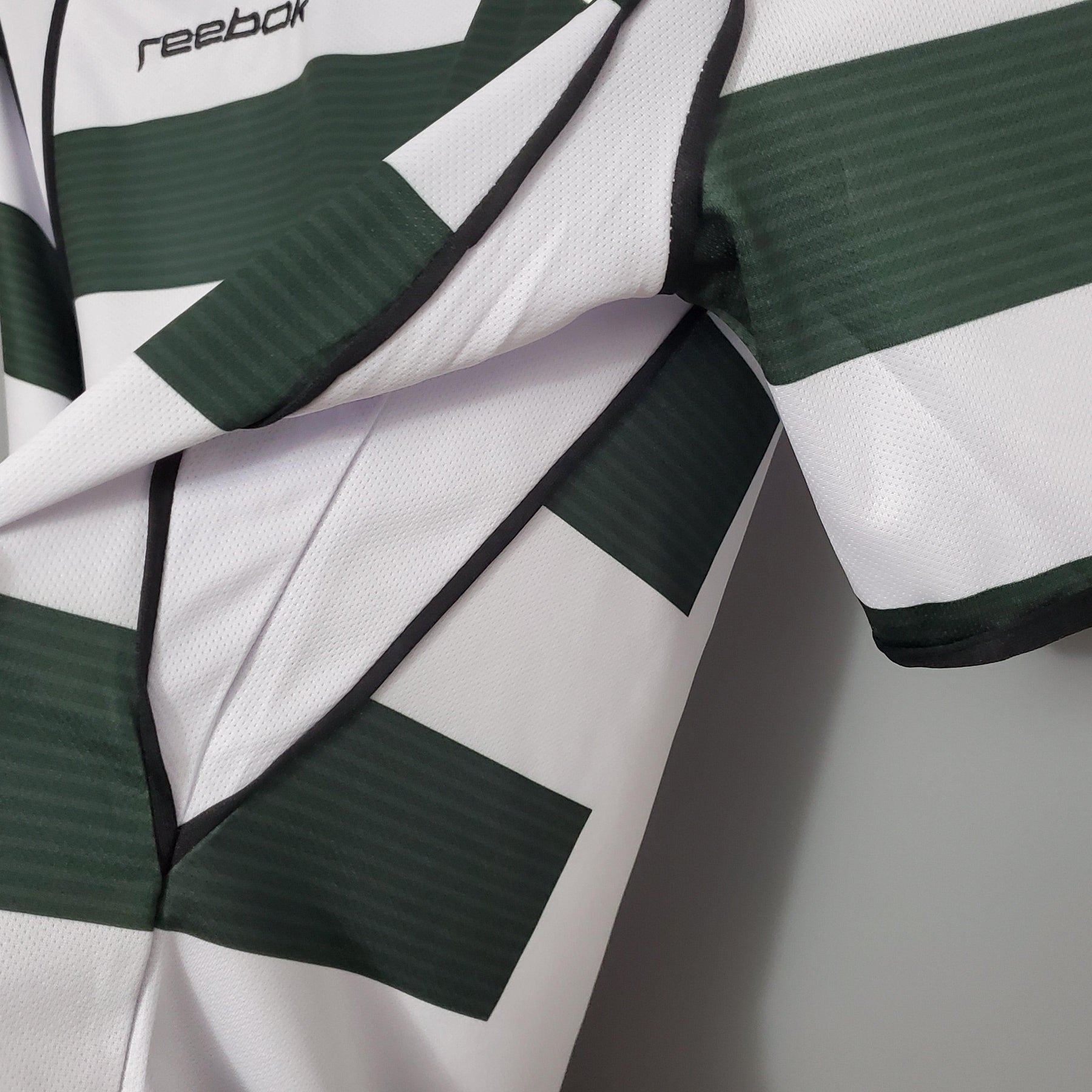 Camisola Sporting Lisboa Home 01/03 Retro com listras verdes e brancas, detalhe da manga em material Reebok.