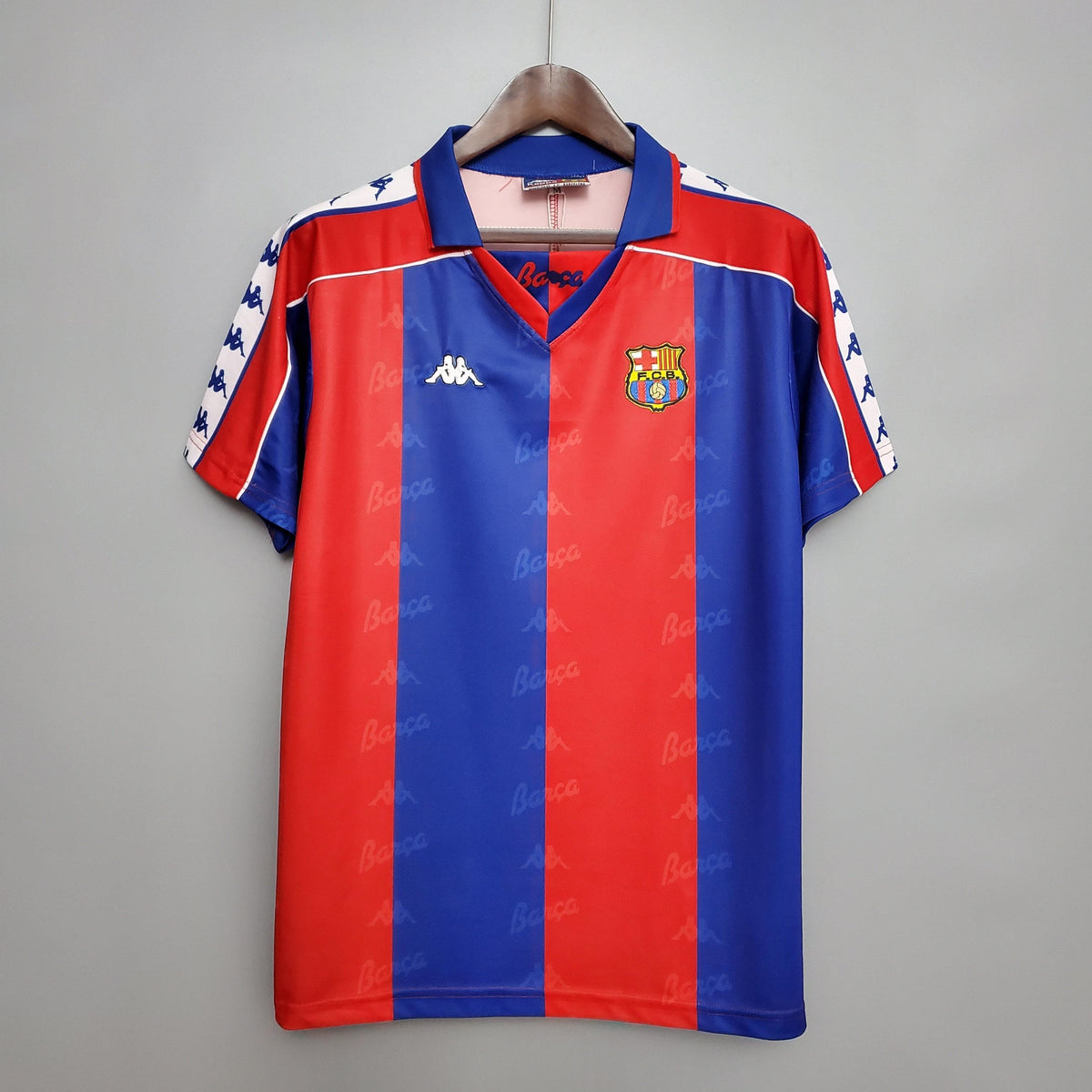 Camisa retro Barcelona 92/93 da loja olímpica, com design vermelho e azul, em destaque.