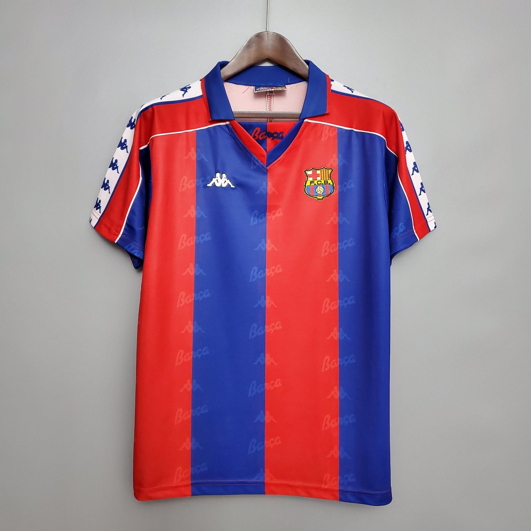 Camisa retro Barcelona 92/93 da loja olímpica, com design vermelho e azul, em destaque.