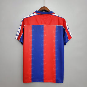Camisa de jogo retro Barcelona 92/93, modelo olímpico, mostrando as cores azul e vermelho.