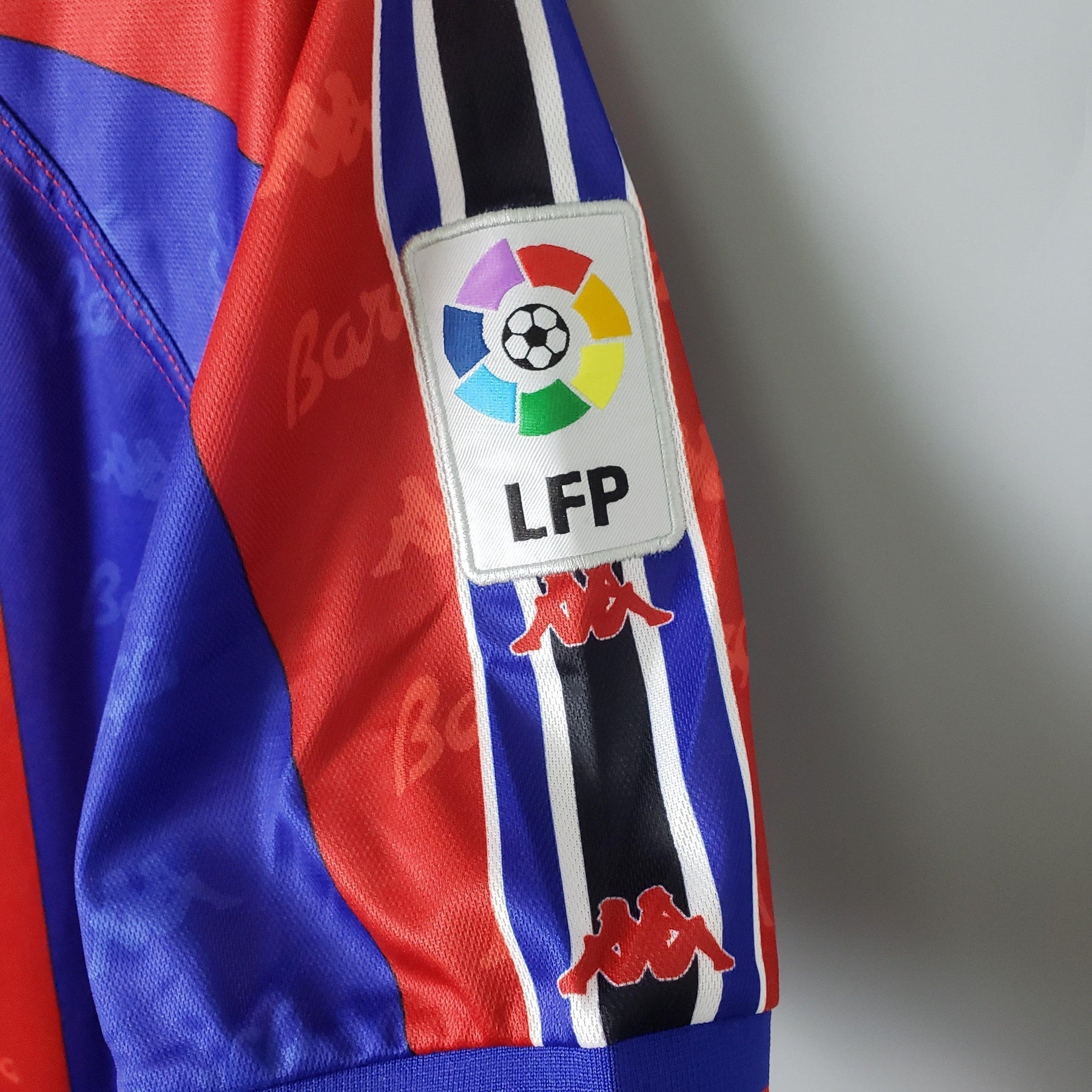 Detalhe da manga da camisola Barcelona Home 96/97 com o logotipo da LFP e cores icônicas do clube.