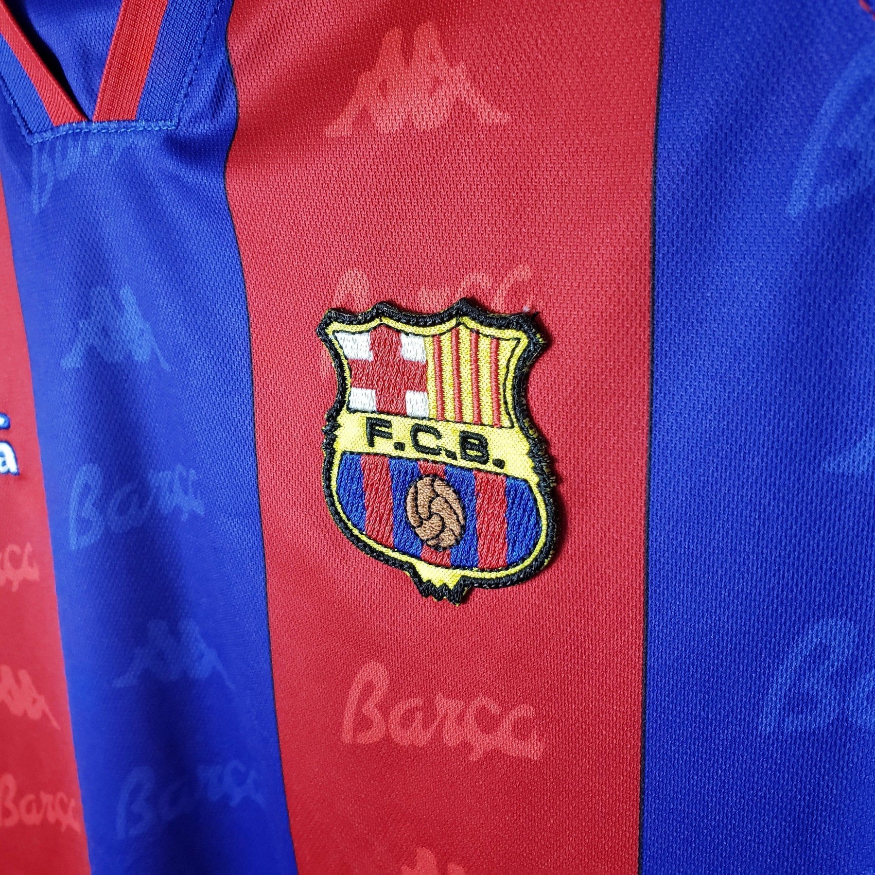 Logotipo do FC Barcelona na camisola Barcelona Home 96/97 Retro Olympic Store.