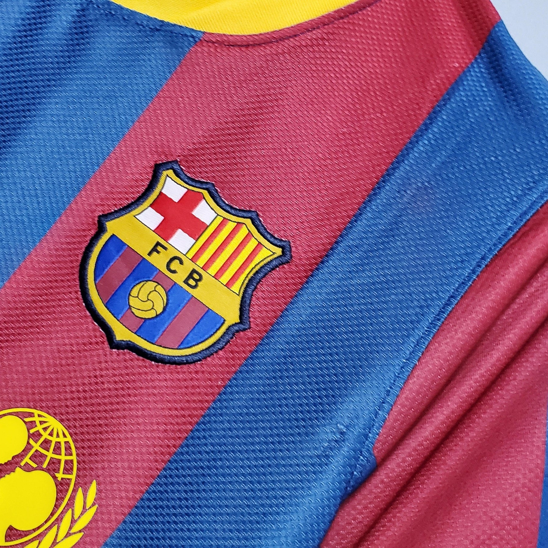 Camisa Barcelona Home 10/11 Retro com escudo detalhado em cores tradicionais.