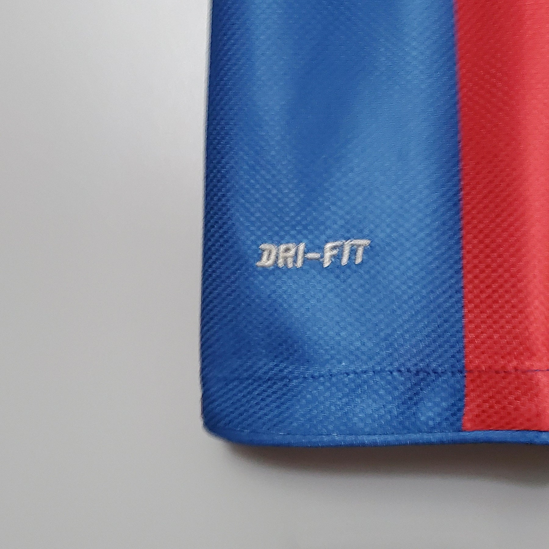 Detalhe do tecido da camisa Barcelona Home 10/11 Retro, com logo DRI-FIT em destaque.