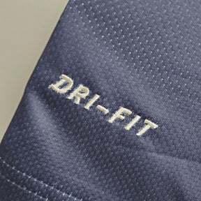 Detalhe do tecido DRI-FIT em camisa PSG Home 13/14 Retro Azul Olympic, destacando a qualidade do material.