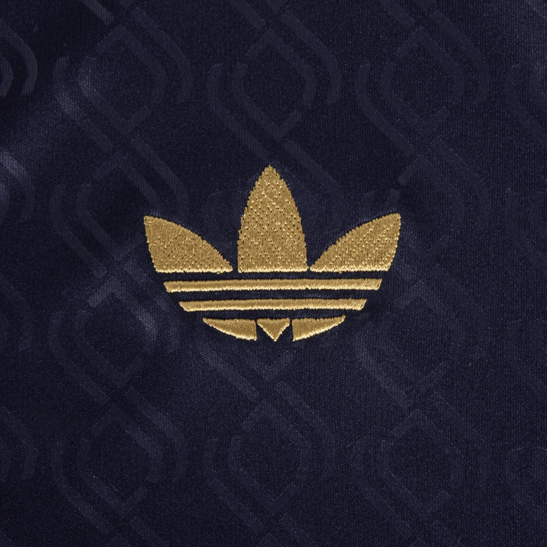 Logotipo dourado da Adidas em fundo azul, destacando o design icônico da marca.