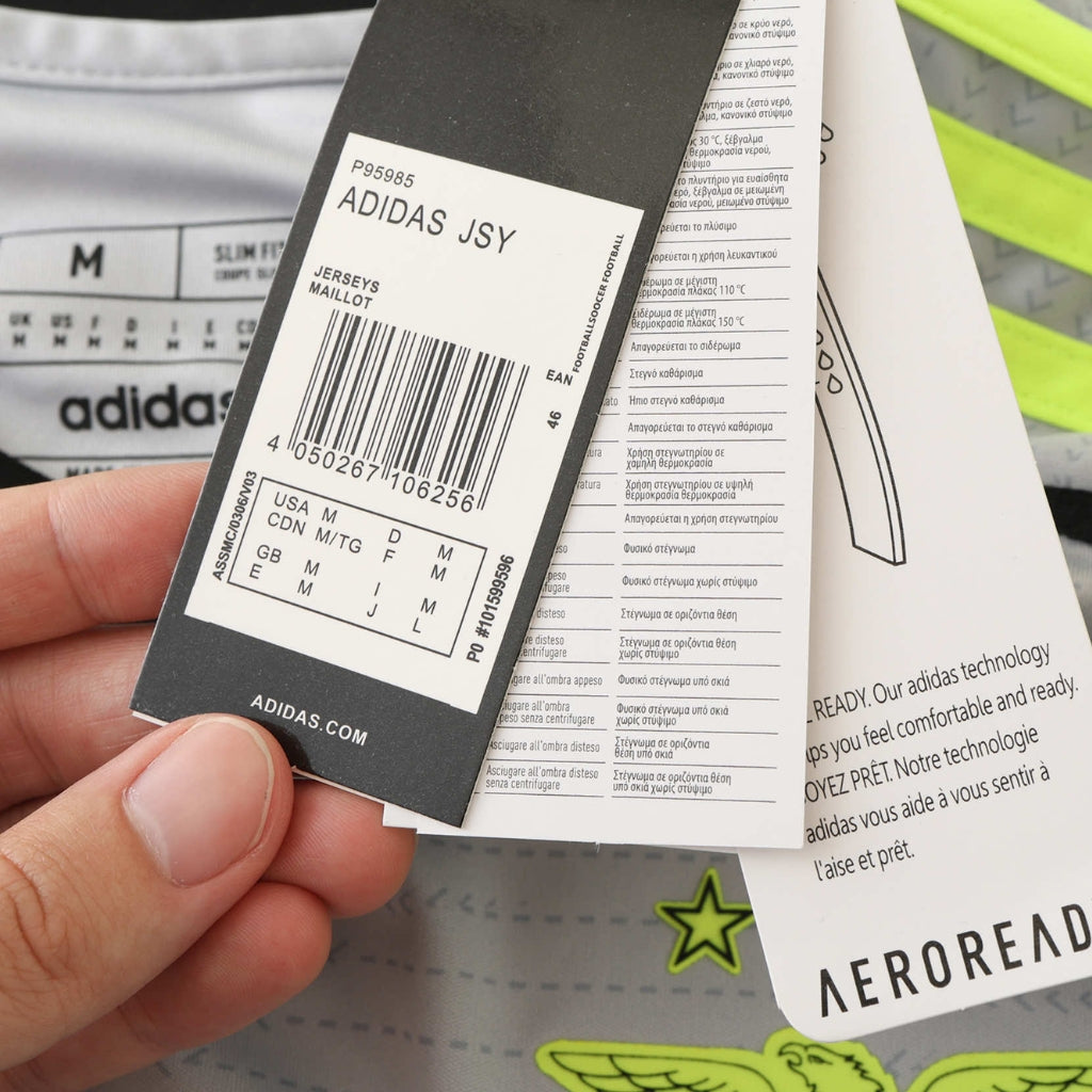 Etiqueta de camisola Adidas mostrando tamanho e instruções de cuidado, ideal para identificar produtos esportivos.