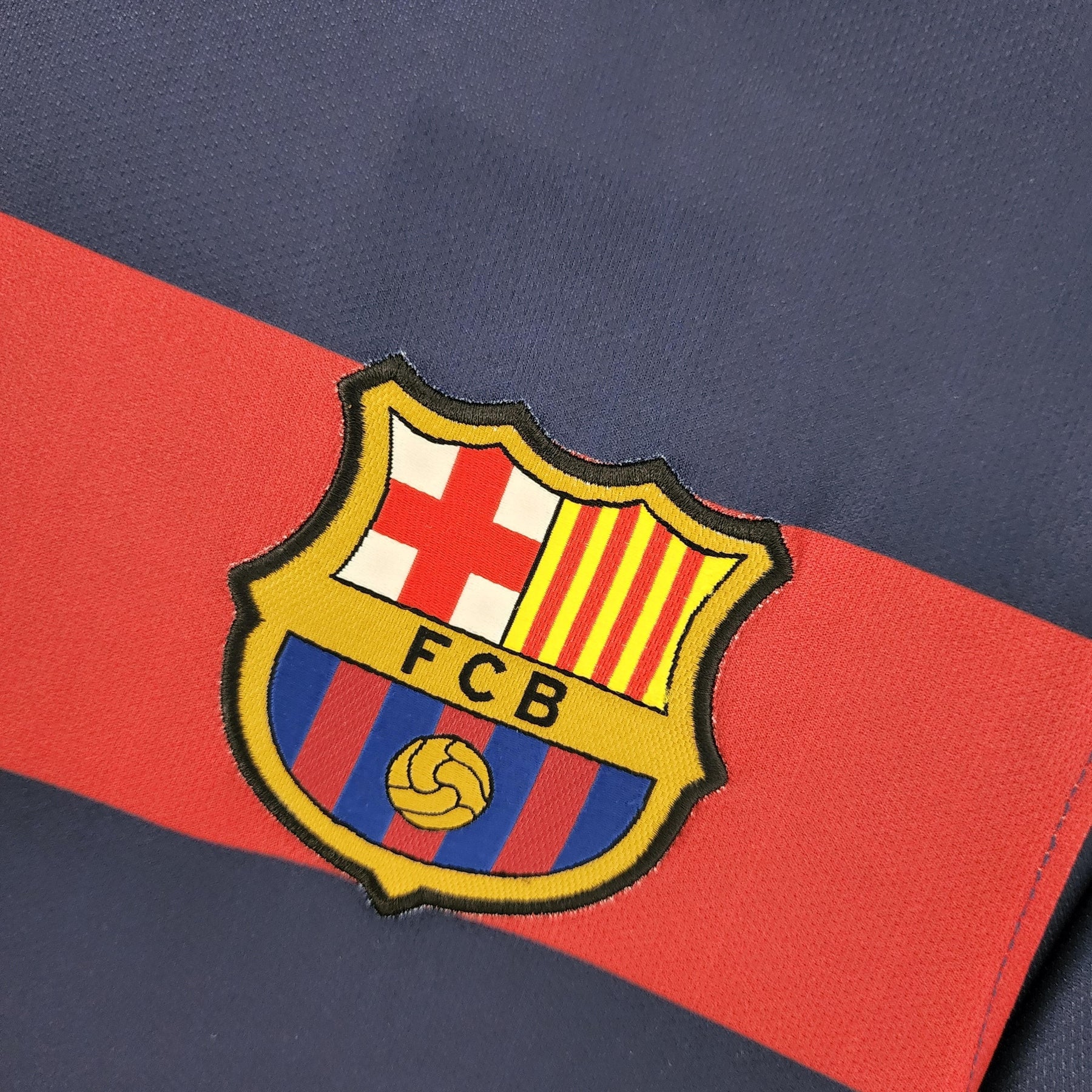 Emblema do Barcelona na camisola da temporada 15/16 da OLYMPIC STORE.