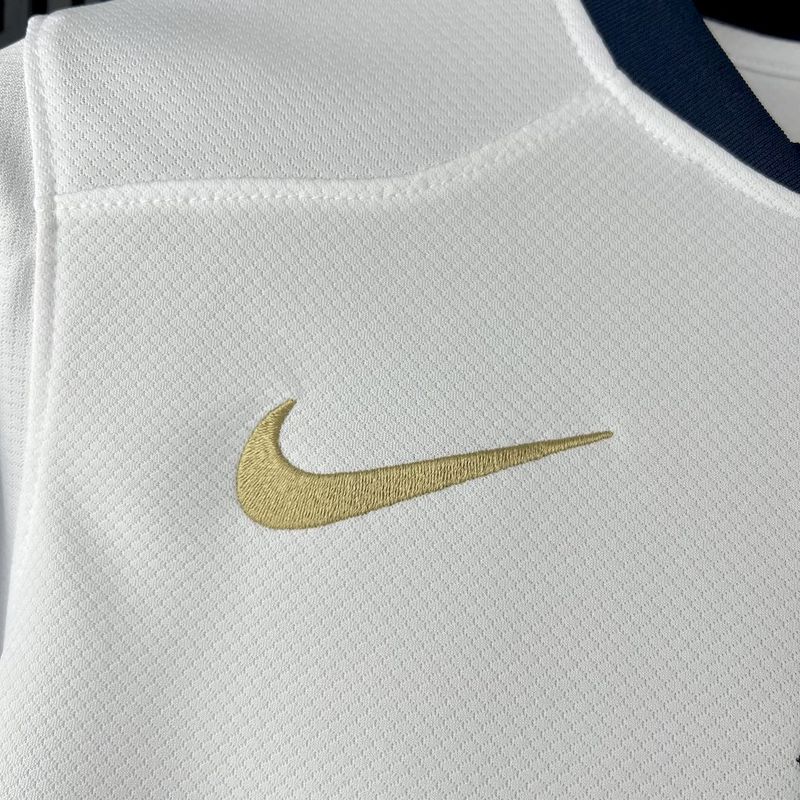 Logo da Nike em dourado em camisola branca, parte de uma nova coleção Barcelona edição especial 25/26.