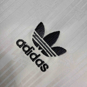 Logotipo Adidas bordado em camisola Alemanha home 1990 Retro, destacando estilo e qualidade.