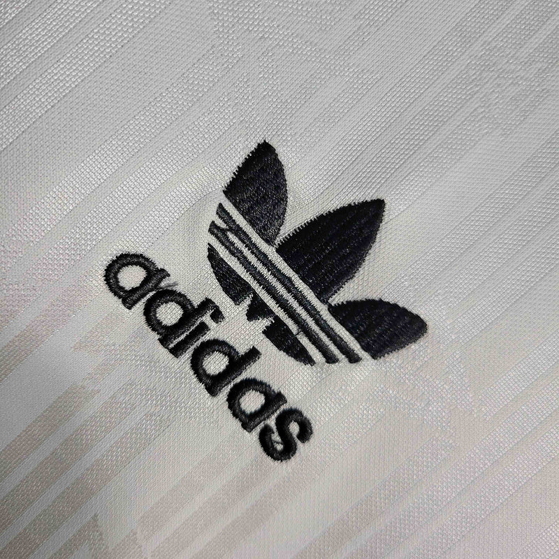 Logotipo Adidas bordado em camisola Alemanha home 1990 Retro, destacando estilo e qualidade.