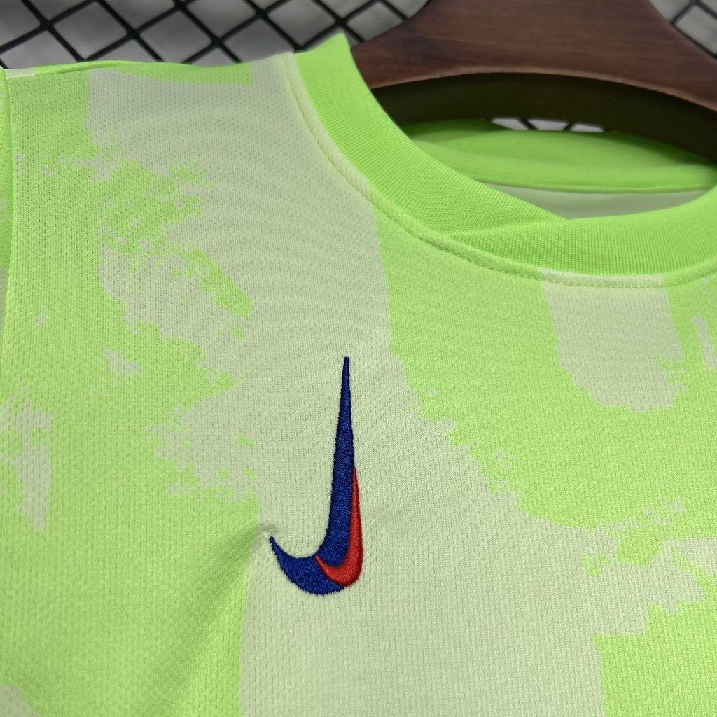 Conjunto Infantil Barcelona third 24/25 detalhe em camiseta verde limão com logo da Nike.
