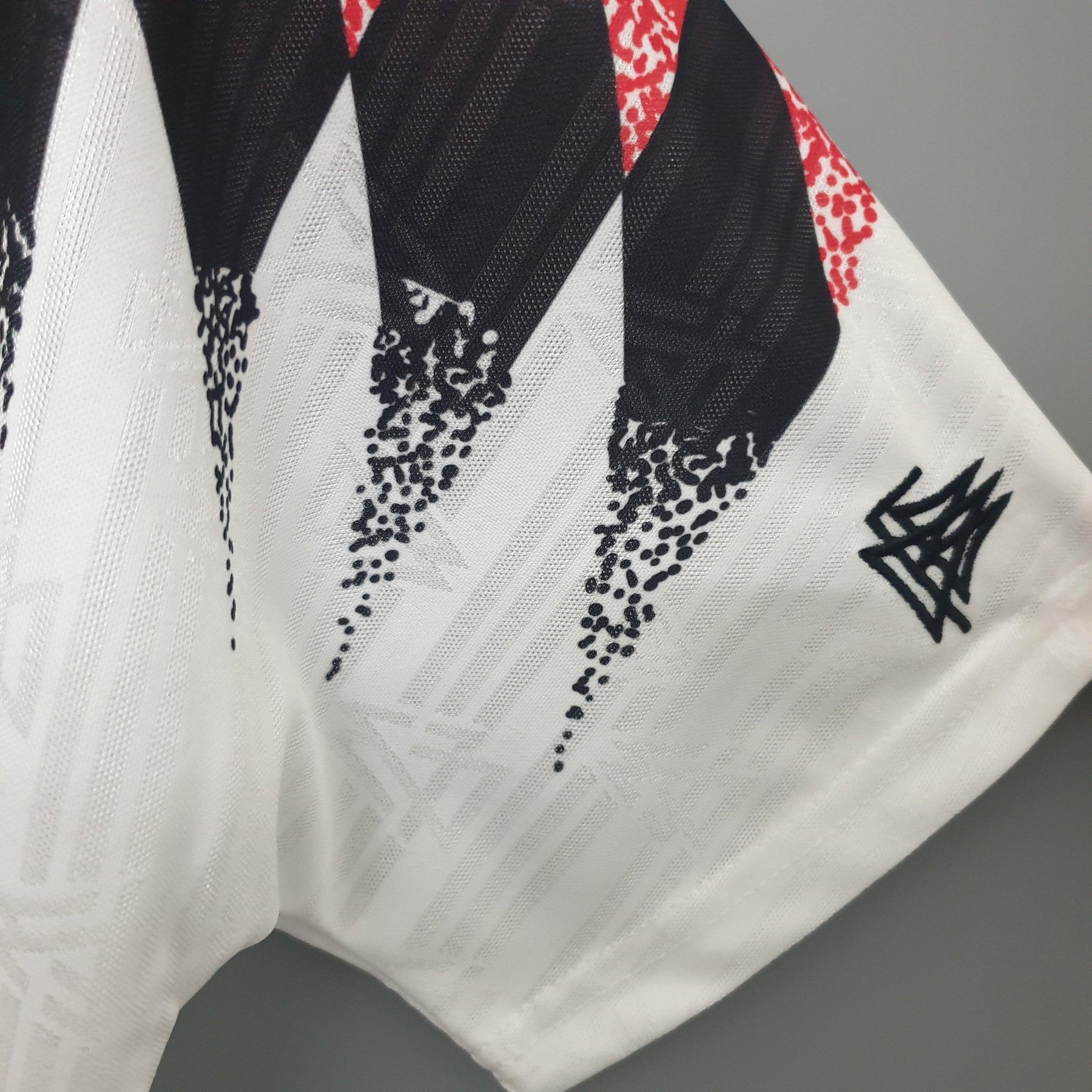 Detalhe da Camisola Alemanha Home 1994 Retro, destacando o design icônico e as cores vibrantes.