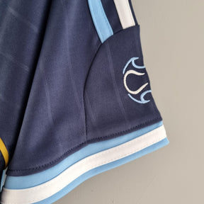 Detalhe da Camisola Argentina Away 06/07 Retro com logo e tecido em azul, ideal para colecionadores e fãs de futebol.