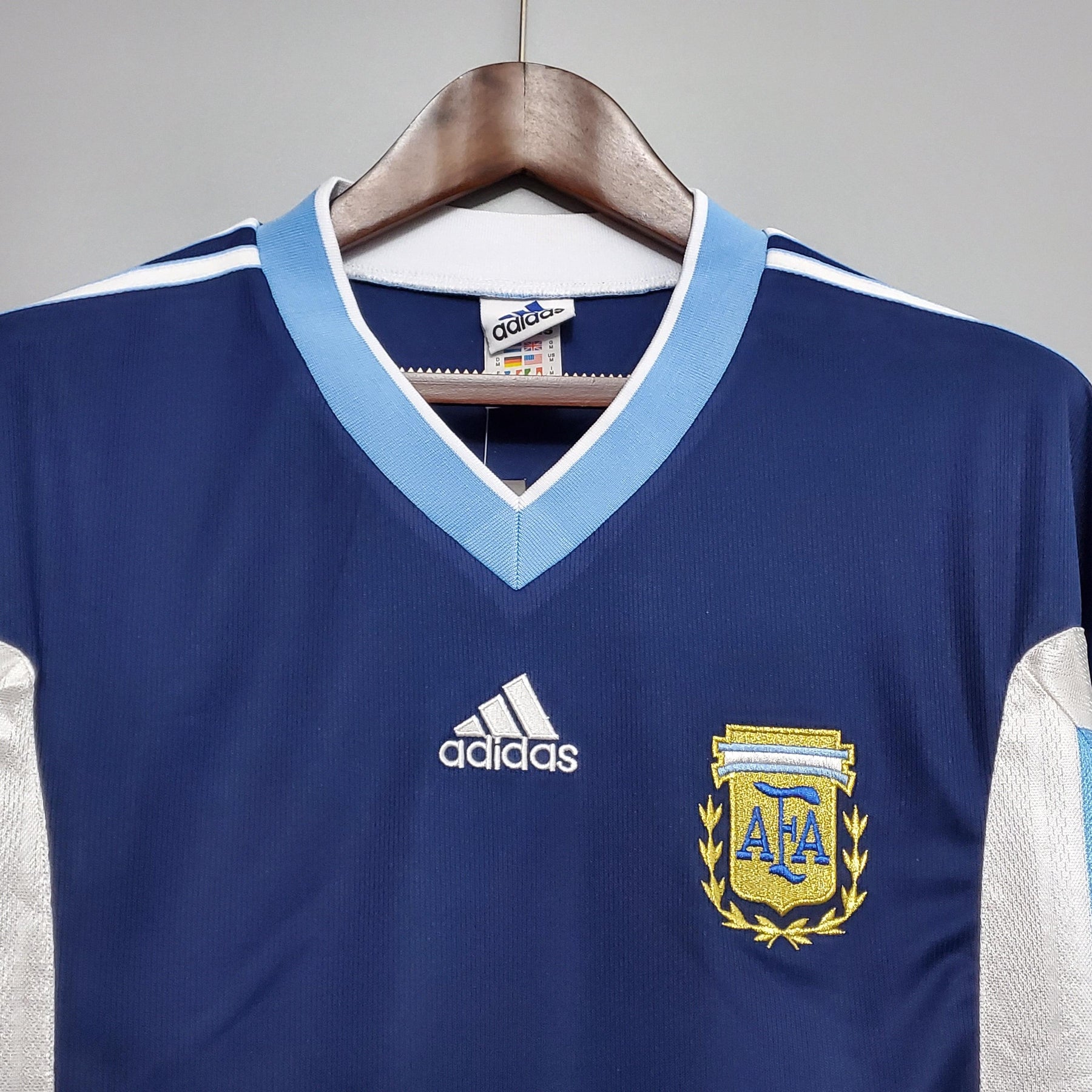 Camisola Argentina Away 98/99 Retro com logo da AFA e detalhes em azul, ideal para colecionadores e fãs de futebol.
