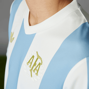 Camisola Argentina home 24/25 - Comemorativa, detalhe do colarinho e emblema da AFA.