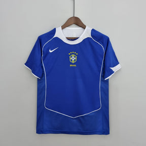 Camisola Brasil Away 04/06 Retro na cor azul, com detalhes em branco e emblema da seleção brasileira.