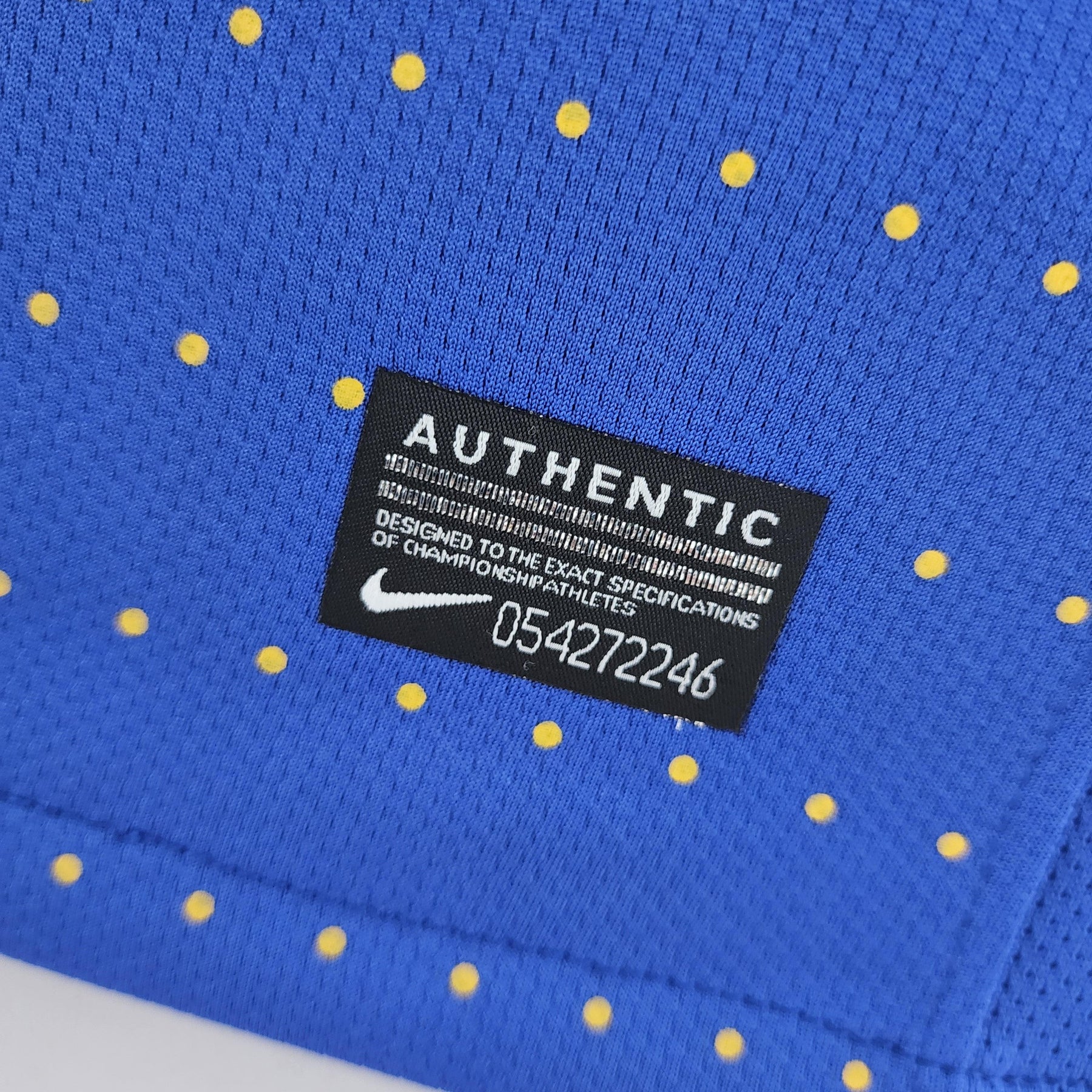 Camisola Brasil Away 2010 Retro com etiqueta de autenticidade e design azul com poás amarelos.