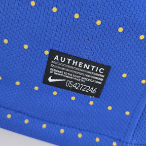 Camisola Brasil Away 2010 Retro com etiqueta de autenticidade e design azul com poás amarelos.
