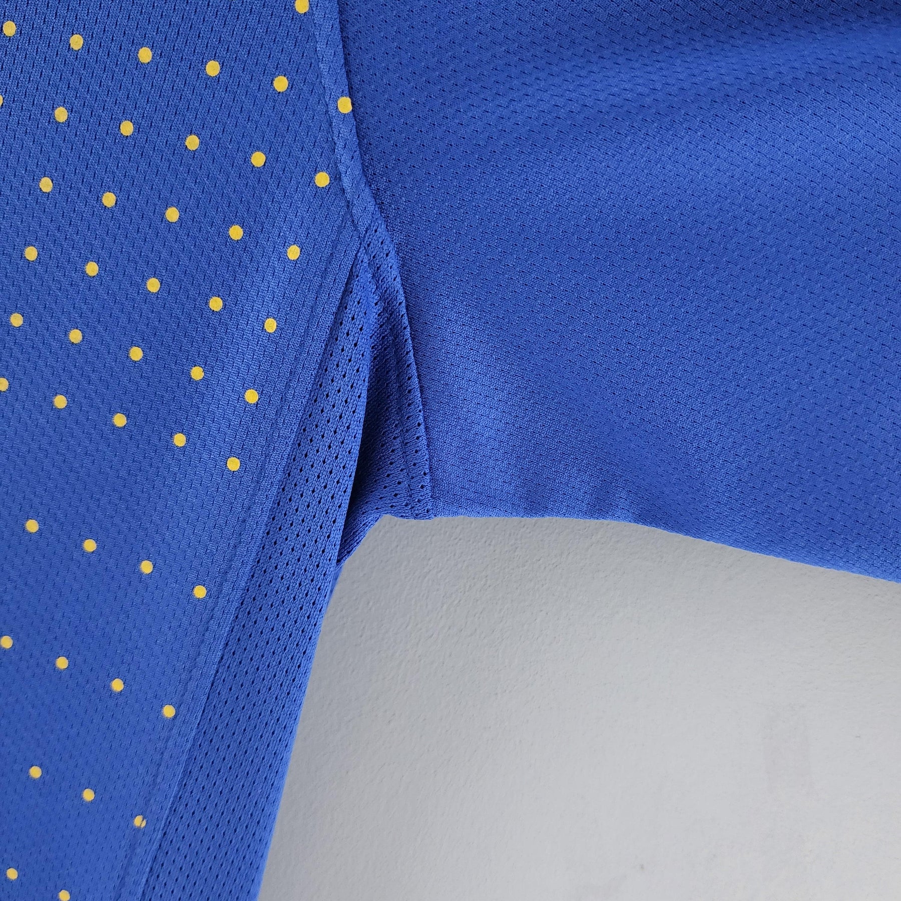 Camisola Brasil Away 2010 Retro em detalhe, mostrando a textura e cor azul com pontos amarelos.
