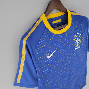 Camisola Brasil Away 2010 Retro em azul com detalhes em amarelo e logo da Nike, destacando a tradição do futebol brasileiro.